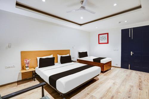 新德里Super Townhouse Yashobhoomi Formerly Hotel Grand Tashree的有两张床和蓝色门的卧室