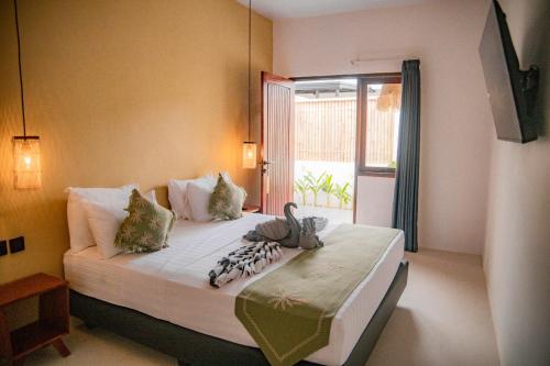 a bedroom with a large bed with a window at Masaya Retreat Lombok in Kuta Lombok