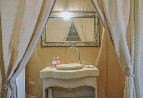 a bathroom with a sink and a mirror at unique Sahara Camp in Merzouga