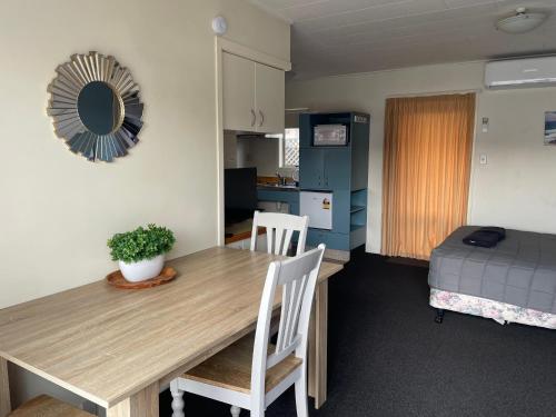 a room with a table and chairs and a bedroom at Bella Tuscany Motor Lodge in Napier