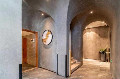 un couloir d'une maison avec une horloge sur le mur dans l'établissement Immersing Hotels & Resort Yunzhu Meiyuan Wuyishan Impression Dahongpao, à Wuyishan