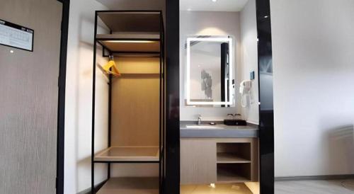 un baño con lavabo y espejo en GreenTree Inn Express Fuzhou Linchuan District Gandong Auto City, en Shiliting