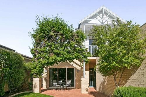 Kingsley Lake House 500Mbps Lakeside Wineries في بيرث: منزل من الطوب مع شرفة وأشجار