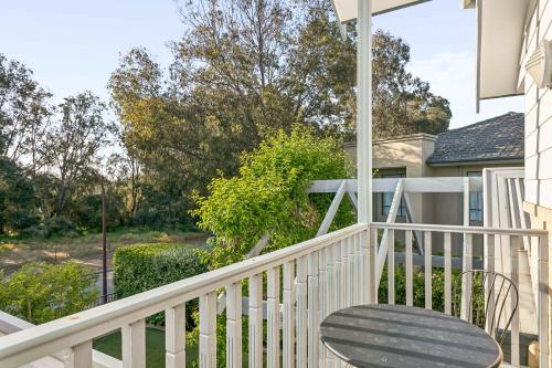 Kingsley Lake House 500Mbps Lakeside Wineries في بيرث: شرفة بيضاء مع كرسي عليها