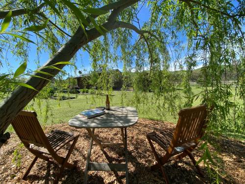 a table and two chairs under a tree at Starlight Lodge in Yea