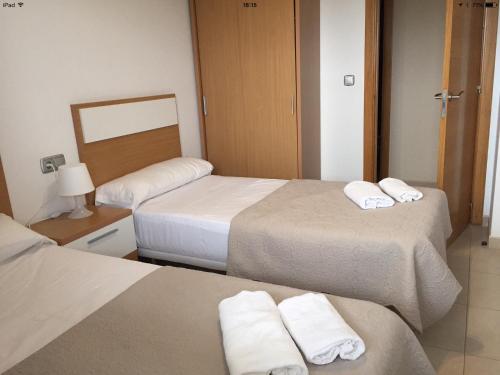 Habitación de hotel con 3 camas y toallas. en Alicante Mar, en Alicante