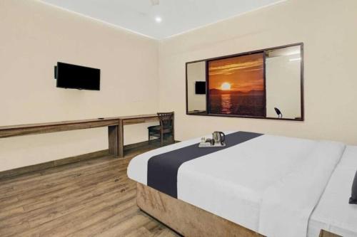 a bedroom with a large bed and a flat screen tv at Townhouse Gomti Nagar Station Formerly Budget In in Gomti Nagar
