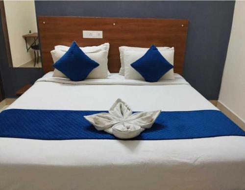 a bed with blue and white sheets and blue pillows at Hotel O Rajahmundry Central Railway Station Formerly Sanjeevi Residency in Godāvari