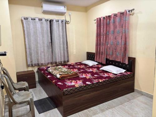 a bedroom with a bed and a chair and curtains at Collection O Asian Highway Near Agrasen Hospital Siliguri Formerly Ashiyana Homestay in Binnāguri