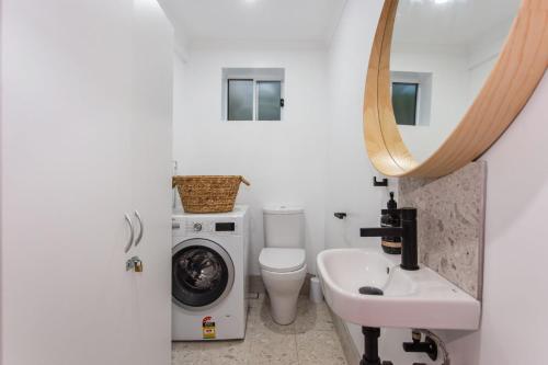 a bathroom with a washing machine and a sink at Jimmys Beach House in Hawks Nest