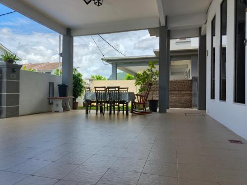 パダン・ブサールにあるChek Embun Homestayの家の中のパティオ(テーブル、椅子付)