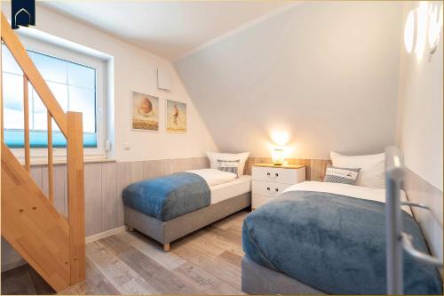 a bedroom with two beds and a window at Ferienhaus Glück unter Reet in Zirchow