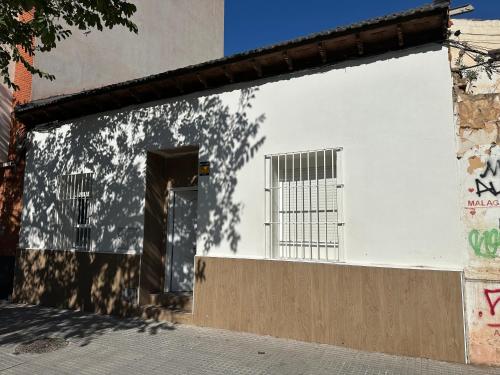 a white building with a door and a window at Casa ARANAL in Málaga