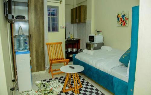 a small bedroom with a bed and a chair at Lapis Studio with Netflix and WI-FI in Nanyuki