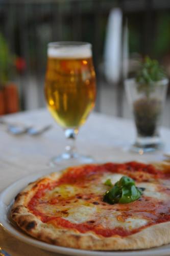 a pizza on a table with a glass of beer at Albergo Ristorante La Torricella in Poppi