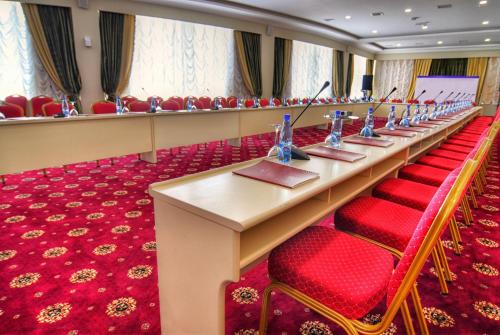 a long table in a room with red chairs at Ramada by Wyndham Baku in Baku