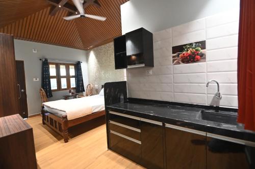 - une cuisine avec évier et un lit dans une chambre dans l'établissement Basilica Residency, à Māvalli