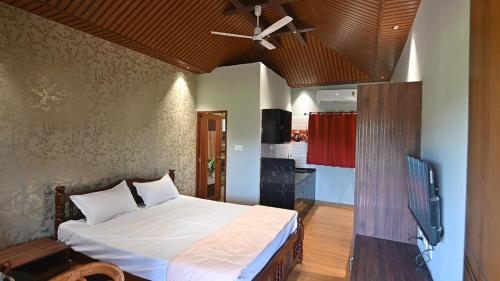 une chambre avec un lit et un ventilateur de plafond dans l'établissement Basilica Residency, à Māvalli