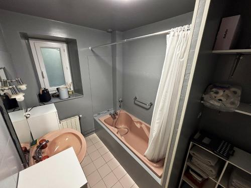 bagno con vasca rosa e lavandino di NESST - Gîte Horse & Dog Friendly Cottage a Saint-Setiers