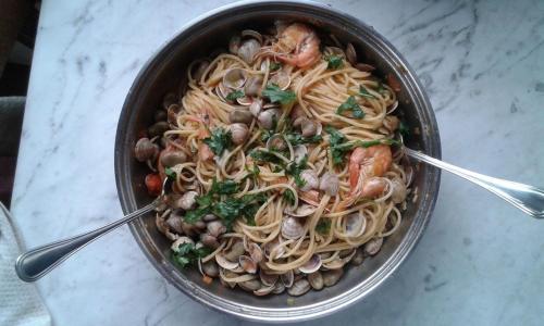a pot of pasta with shrimp and mushrooms on a table at Monolocale fronte strada Napoli centro storico in Naples