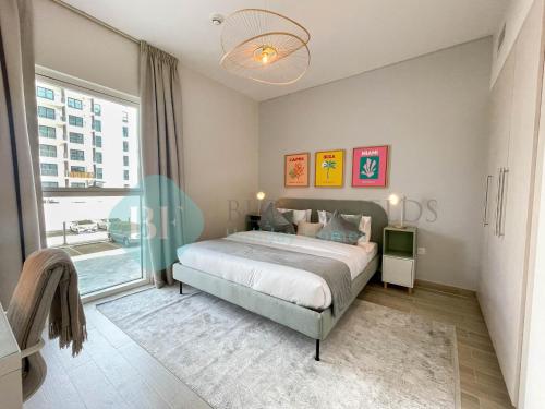a bedroom with a bed and a large window at Bloomfields Relaxing 1Br in Yas Island Waters Ed in Yas Island