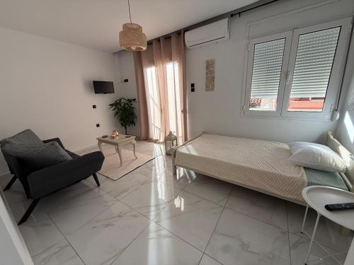 a bedroom with a bed and a couch and a chair at CasaKallisti in Levádeia