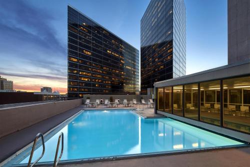 a swimming pool on top of a building with tall buildings at Hyatt Regency Tulsa Downtown in Tulsa