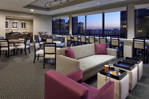 a restaurant with a couch and tables and chairs at Hyatt Regency Tulsa Downtown in Tulsa
