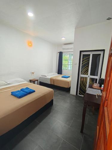 a bedroom with two beds and a desk and a mirror at Perhentian Najmi Hotel in Perhentian Islands