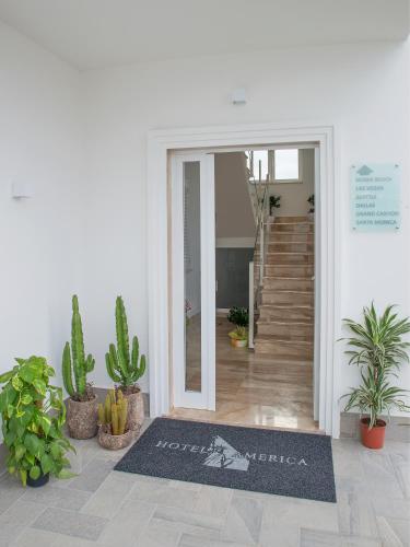 a lobby with a door with a sign that reads entrance at Hotel America in Scafati