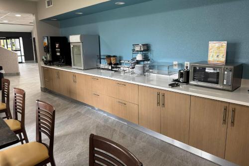una cocina con encimera y microondas en Days Inn by Wyndham McDonough, en McDonough