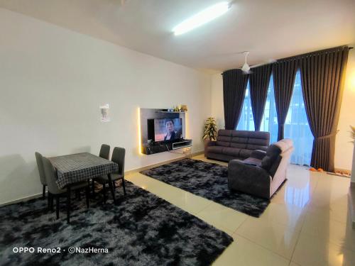 a living room with a couch and a table and a television at NH Stay, Parit Buntar Perak in Parit Buntar