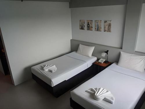 a room with two beds and a table with a lamp at Thai Hotel Krabi in Krabi town