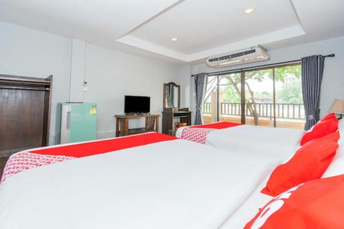 a bedroom with two beds and a balcony at OYO 884 Baan Sang Chan Cha-am in Ban Sahakham
