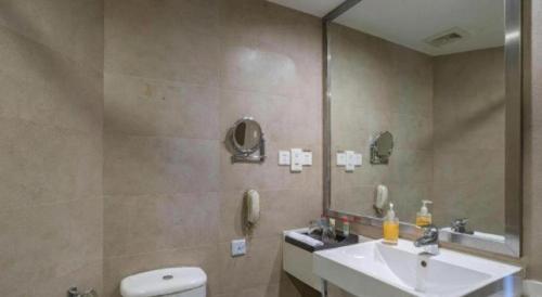 a bathroom with a sink and a toilet and a mirror at Ramada by Wyndham Wujiaochang Shanghai in Shanghai