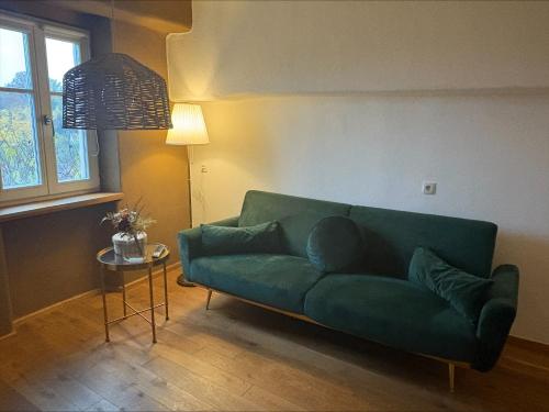 a green couch in a living room with a table at Schlossblick in Sulzbach-Rosenberg