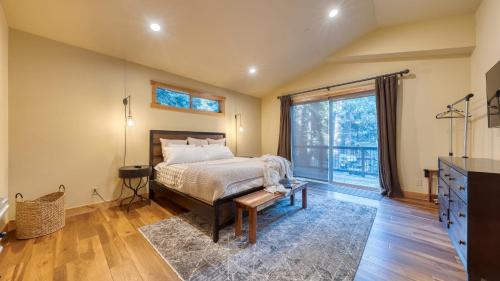 ein Schlafzimmer mit einem Bett und einem großen Fenster in der Unterkunft Cozy Tahoe Retreat w Hot Tub Movie Room Forest Views 10th ave 2 by AvantStay in Tahoma