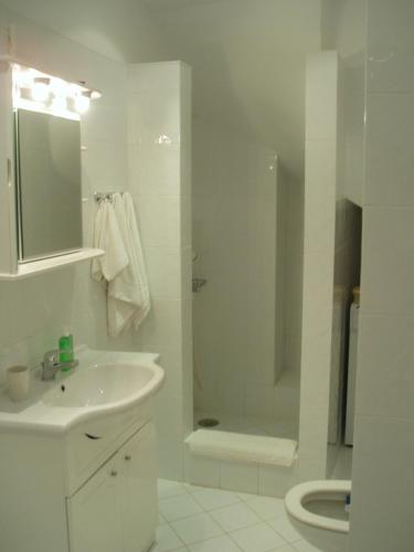 a white bathroom with a sink and a shower at Τhe White Houses in Makry Gialos