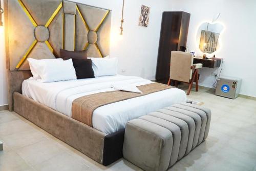 カラバルにあるLincolyn royale hotel calabarのベッドルーム(大型ベッド1台、ベンチ付)