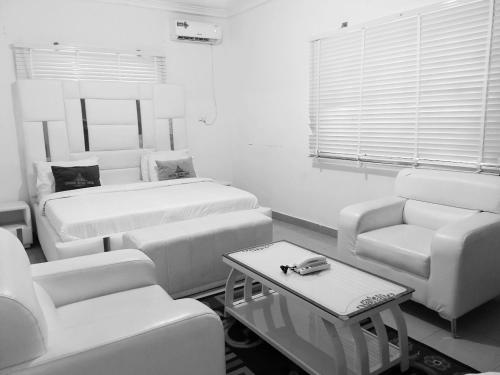 カラバルにあるLincolyn royale hotel calabarのベッド2台とソファ1台とテーブル1台がある部屋