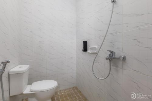 a bathroom with a shower with a toilet and a phone at SG Hotel Pangandaran in Pangandaran