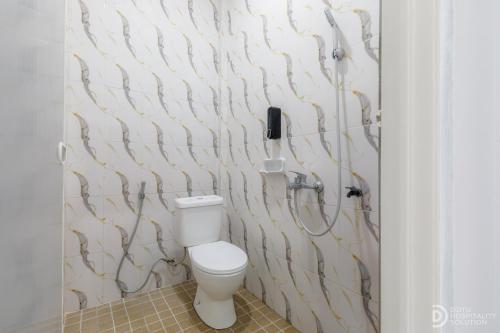 Un baño con inodoro y ducha en SG Hotel Pangandaran, en Pangandaran