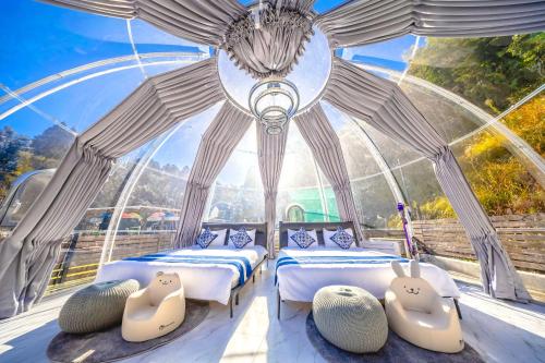 two beds in a room with a glass dome at Dream Dome Glamping Studio Ichihara in Ichihara