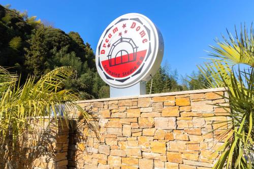 a sign on top of a brick wall at Dream Dome Glamping Studio Ichihara in Ichihara