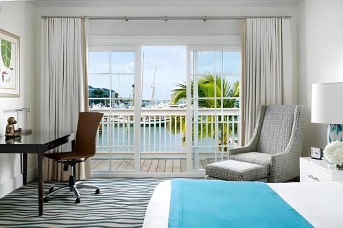 une chambre d'hôtel avec un lit, un bureau et une fenêtre dans l'établissement The Marker Key West Harbor Resort, à Key West