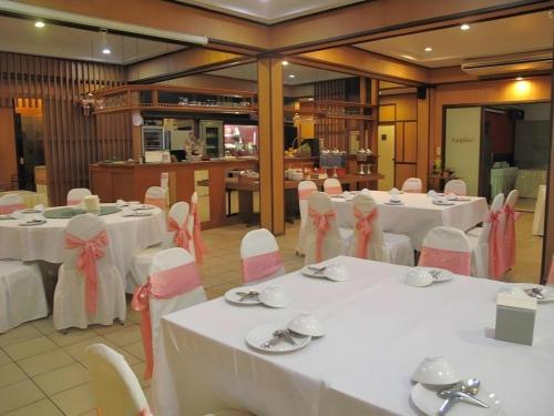 une salle de banquet avec des tables blanches et des chaises blanches dans l'établissement Dusit Hotel, à Sakon Nakhon