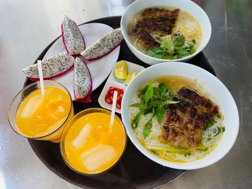 Un plato de comida con tazones de sopa y fideos. en The Valley Lodge Trang An, en Ninh Binh