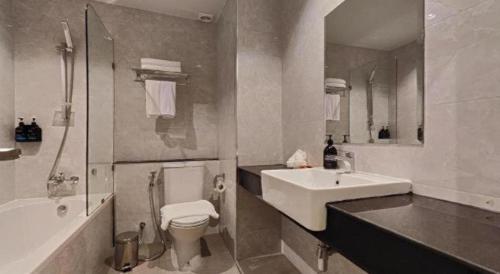a bathroom with a sink and a toilet and a tub at Butterfly Princess Hotel in Ban Komo Sip Paet
