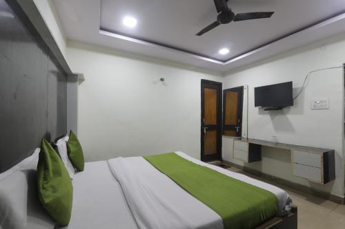 Un dormitorio con una cama y un televisor de pantalla plana. en Hotel Dayal, en Lucknow