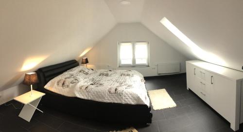 a attic bedroom with a bed and a window at Haus Kummer in Selm